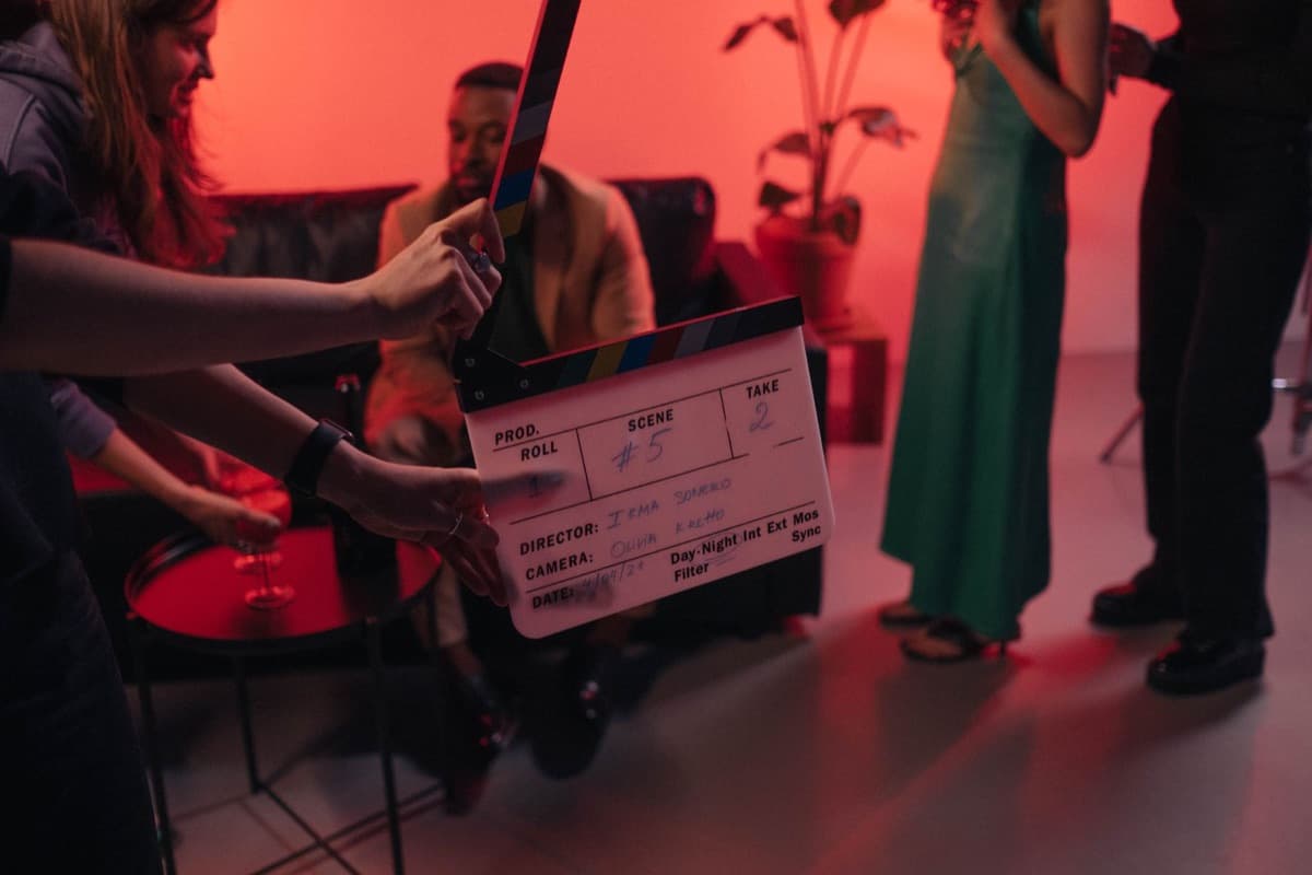 A clapperboard held up on a small set lit in red, ready for the next take
